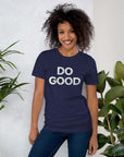 Smiling woman wearing navy Milk Sandwich T-shirt with distressed white DO GOOD text, standing indoors next to plants, casual inspirational tee.
