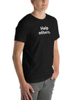 Angled view of man wearing black Milk Sandwich T-shirt with distressed white Help others. slogan, clean and modern unisex graphic tee.