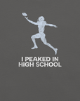 Close-up of asphalt Milk Sandwich T-shirt with distressed white football player graphic and text I Peaked in High School, ironic athletic nostalgia tee.