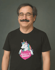 Smiling man with glasses and mustache wearing a black t-shirt with a colorful unicorn graphic and the text “Believe in Edibles” inside a pink heart.