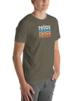 Angled front view of a man wearing a Milk Sandwich army t-shirt with a colorful distressed relax text design repeated vertically in white, blue, orange, and pink.