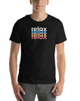 Man wearing a Milk Sandwich black t-shirt with a colorful stacked relax text design in white, blue, orange, and pink distressed print.