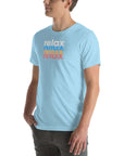 Side view of a man wearing a Milk Sandwich ocean blue t-shirt featuring a stacked relax text design in distressed white, blue, orange, and pink colors.