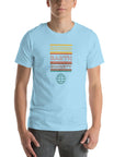 Man wearing a Milk Sandwich ocean blue t-shirt with a colorful retro-style "ROUND EARTH SOCIETY" graphic and globe icon on the front.