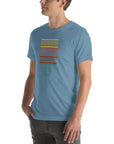 Angled side view of a person wearing a steel blue Milk Sandwich t-shirt with a colorful "Round Earth Society" graphic design.