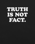 Close-up of black Milk Sandwich T-shirt with bold white text that reads Truth Is Not Fact, minimalist graphic tee with a bold statement.