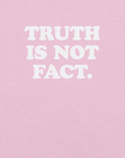Close-up of pink Milk Sandwich T-shirt with bold white text that reads Truth Is Not Fact, minimalist graphic tee with a bold statement.