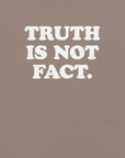 Close-up of pebble Milk Sandwich T-shirt with bold white text that reads Truth Is Not Fact, minimalist graphic tee with a bold statement.