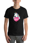 Man wearing a black t-shirt with a colorful unicorn holding a pink heart that says “Believe in Edibles,” standing facing forward with one hand relaxed and the other in his pocket.
