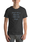 Man wearing dark grey “DON’T BE A PEE PEE POO POO HEAD” t-shirt, standing casually with hands by pockets.