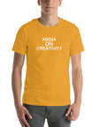Man wearing a mustard t-shirt with the text ‘HIGH ON CREATIVITY’ in bold white capital letters, centered on the chest