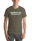 Man wearing army “I ABSORBED MY TWIN (What’s your super power?)” t-shirt, standing facing forward with hands relaxed.