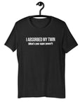 Black t-shirt hanging on a hanger with white text “I ABSORBED MY TWIN (What’s your super power?)” on the front.