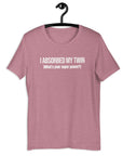 Orchid t-shirt hanging on a hanger with white text “I ABSORBED MY TWIN (What’s your super power?)” on the front.