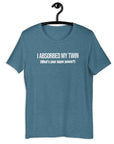 Teal t-shirt hanging on a hanger with white text “I ABSORBED MY TWIN (What’s your super power?)” on the front.
