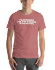 Man wearing mauve “PRETENDING I’M NOT STONED IS MY SUPERPOWER” t-shirt, standing casually with hands by pockets.