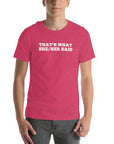 Man wearing pink “THAT’S WHAT SHE/HER SAID” t-shirt, hands in pockets, looking relaxed to the front