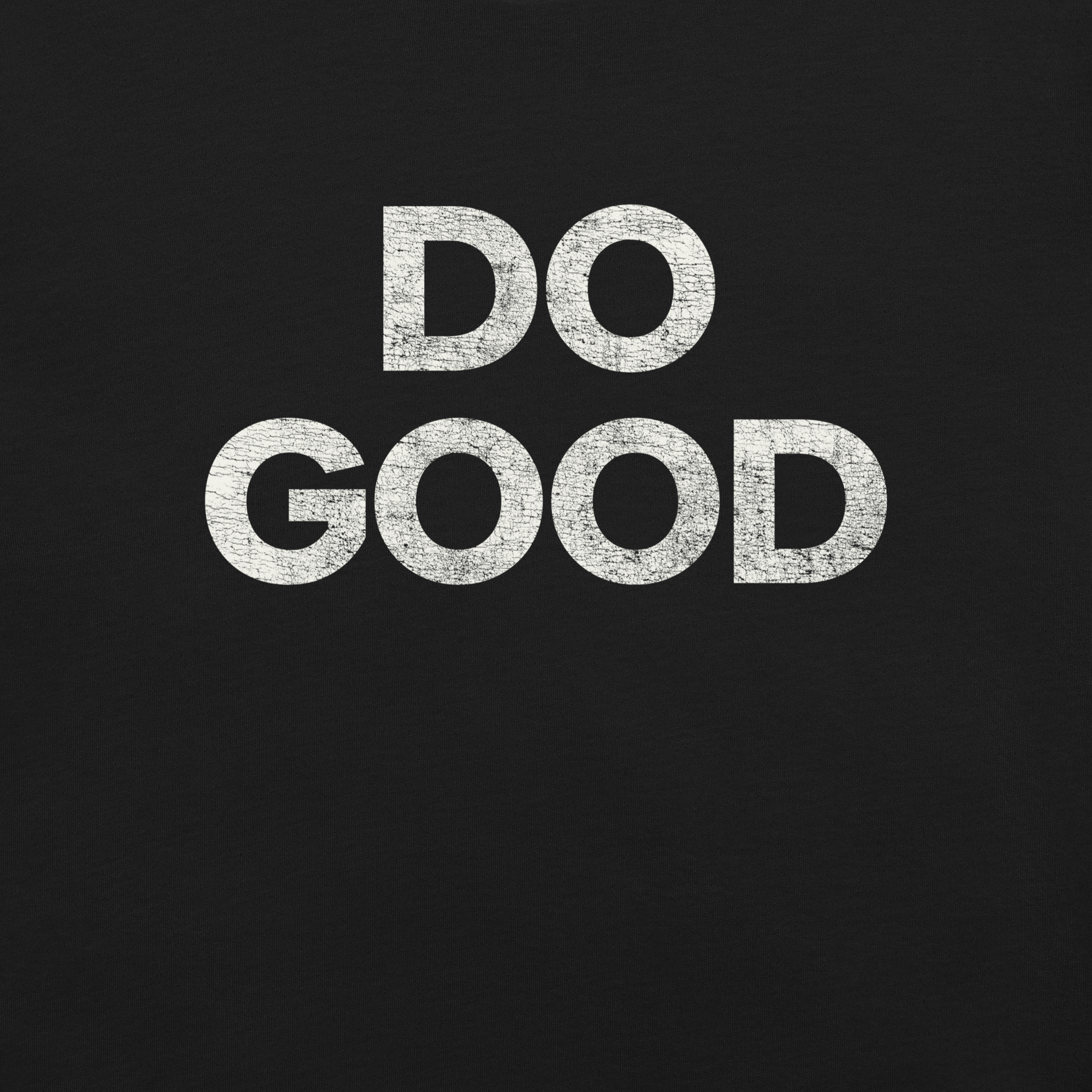 Close-up of black Milk Sandwich T-shirt with bold distressed white text that reads DO GOOD, minimalist motivational graphic tee.