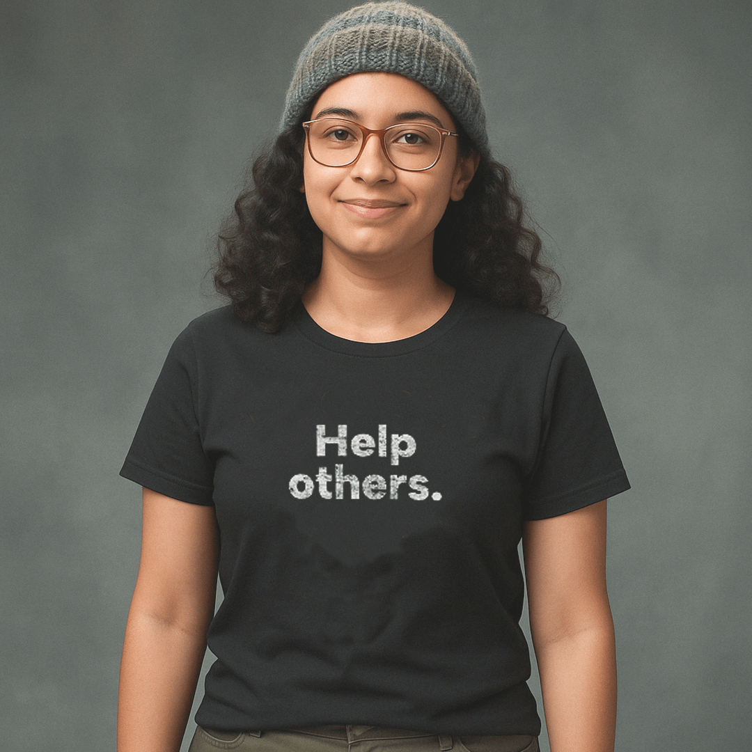 Smiling woman in glasses and knit beanie wearing black Milk Sandwich T-shirt with distressed white text that reads Help others. minimalist graphic tee.