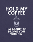 Close-up of heather midnight navy Milk Sandwich T-shirt with white bold text Hold My Coffee, I'm About to Prove You Wrong and a cute steaming coffee cup graphic.