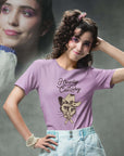 Smiling young woman in pink Milk Sandwich T-shirt with Howdy CatBoy text and illustrated cowboy cat graphic, retro-inspired pastel aesthetic.