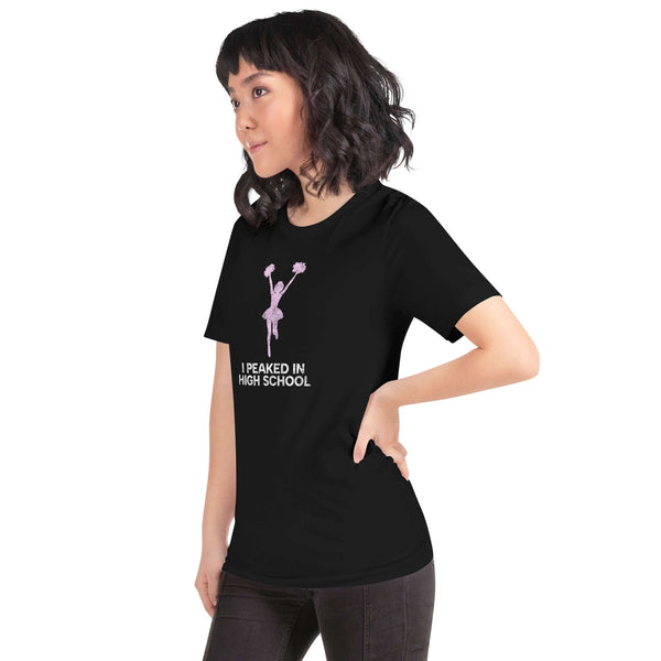 Unisex "I Peaked in High School" Milk Sandwich T-shirt displayed on a woman, showcasing a fun cheerleading design in dark color.