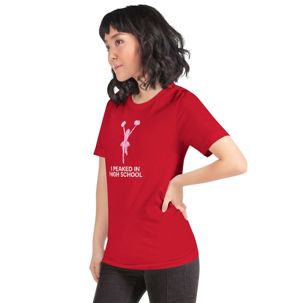 Young woman in a red Milk Sandwich T-shirt with "I Peaked in High School" print, showcasing a fun and casual style.