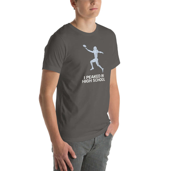 asphalt Milk Sandwich unisex t-shirt 'I Peaked in High School Football' worn by a model, perfect for tailgates and sports nostalgia.