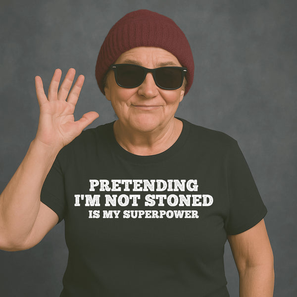 Older woman in sunglasses and beanie wearing “PRETENDING I’M NOT STONED IS MY SUPERPOWER” t-shirt, waving and smiling.          Preguntar a ChatGPT