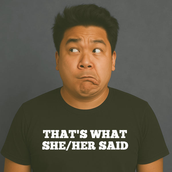 Man making a funny face, wearing a black “THAT’S WHAT SHE/HER SAID” t-shirt, looking off to the side.