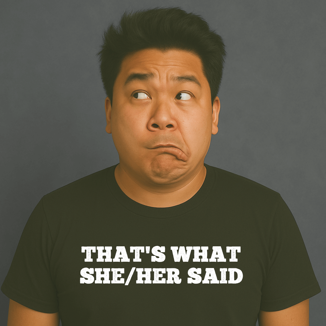 Man making a funny face, wearing a black “THAT’S WHAT SHE/HER SAID” t-shirt, looking off to the side.