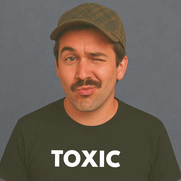 Man with mustache and cap winking while wearing a black “TOXIC” t-shirt, looking playful.