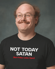 Smiling man with glasses and mustache wearing black Milk Sandwich T-shirt with bold text Not Today Satan (But Friday Looks Open) in studio portrait.