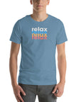 Man wearing a Milk Sandwich steel blue t-shirt with a colorful stacked relax text design in white, blue, orange, and pink distressed print.