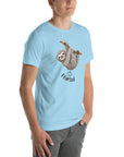Side view of a man wearing a light blue Milk Sandwich t-shirt featuring a playful cartoon sloth hanging from a branch with the phrase I farted and a small puff cloud illustration underneath.