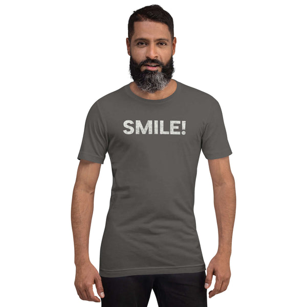 Man wearing a asphalt Milk Sandwich t-shirt with the word "SMILE!" in bold, distressed white lettering across the chest, standing confidently against a plain background.