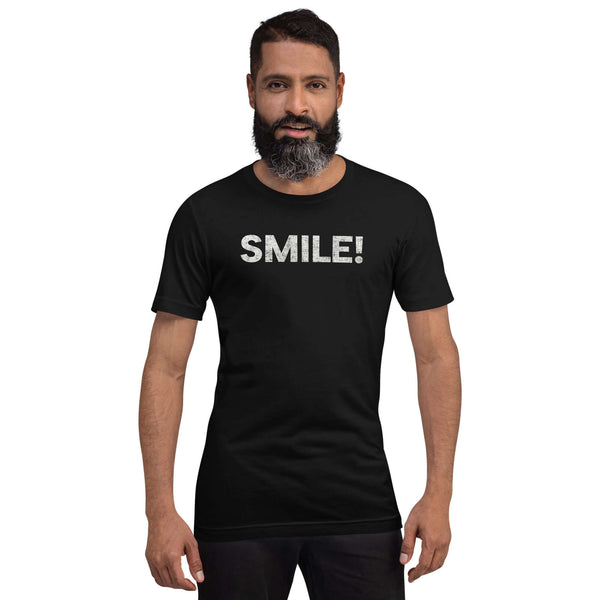 Man wearing a black Milk Sandwich t-shirt with the word "SMILE!" in bold, distressed white lettering across the chest, standing confidently against a plain background.