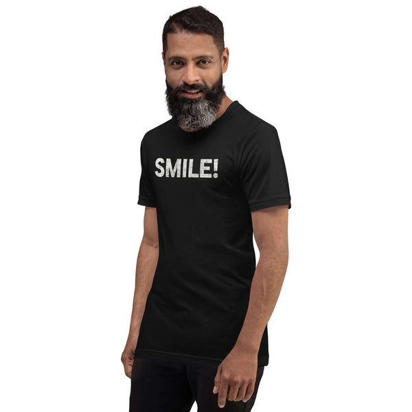 Man in a black Milk Sandwich t-shirt featuring the word "SMILE!" in bold, distressed white letters, posing confidently with a slight turn against a white background.