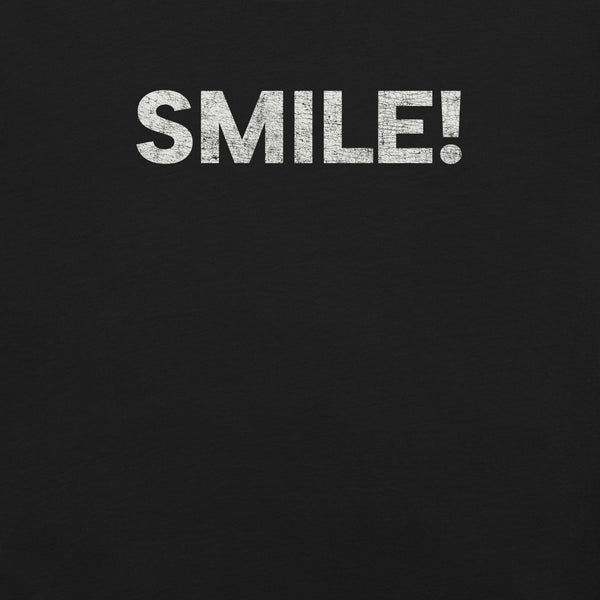 Close-up of a black Milk Sandwich t-shirt with the word "SMILE!" printed in bold, distressed white text across the chest.
