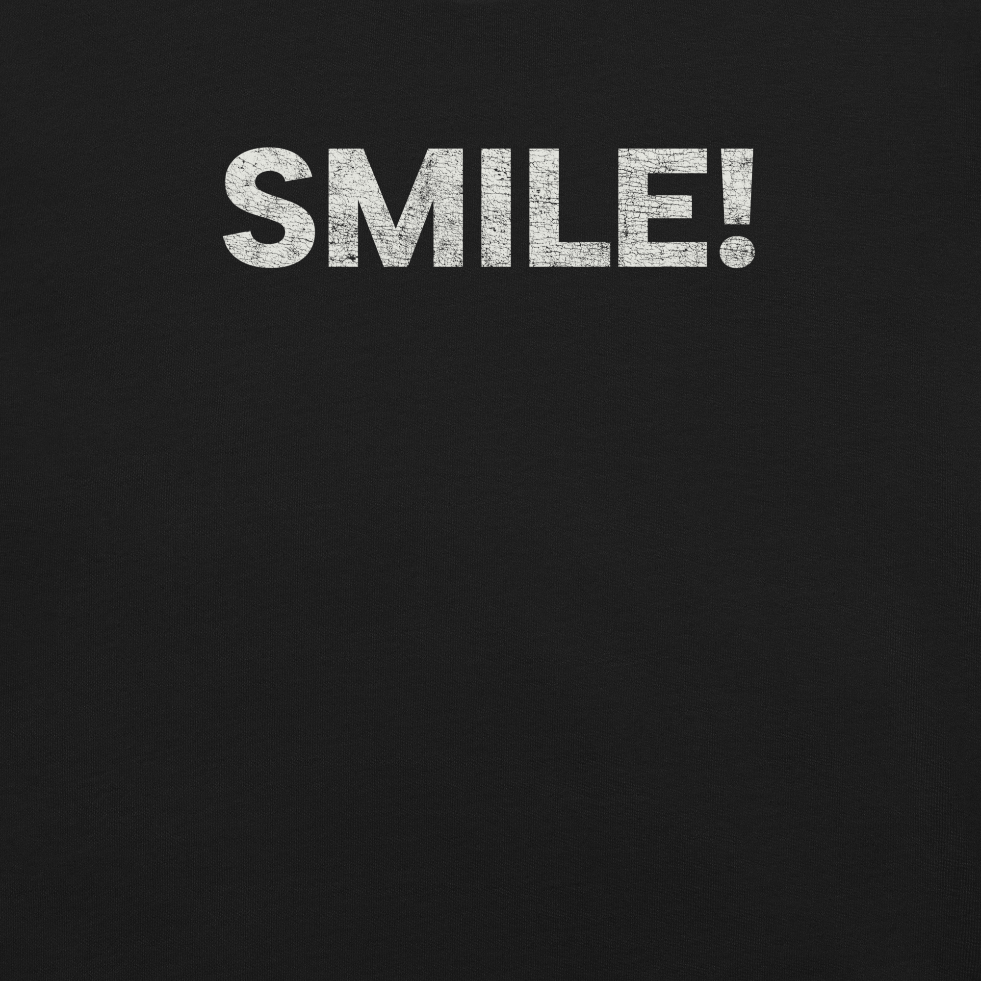 Close-up of a black Milk Sandwich t-shirt with the word "SMILE!" printed in bold, distressed white text across the chest.