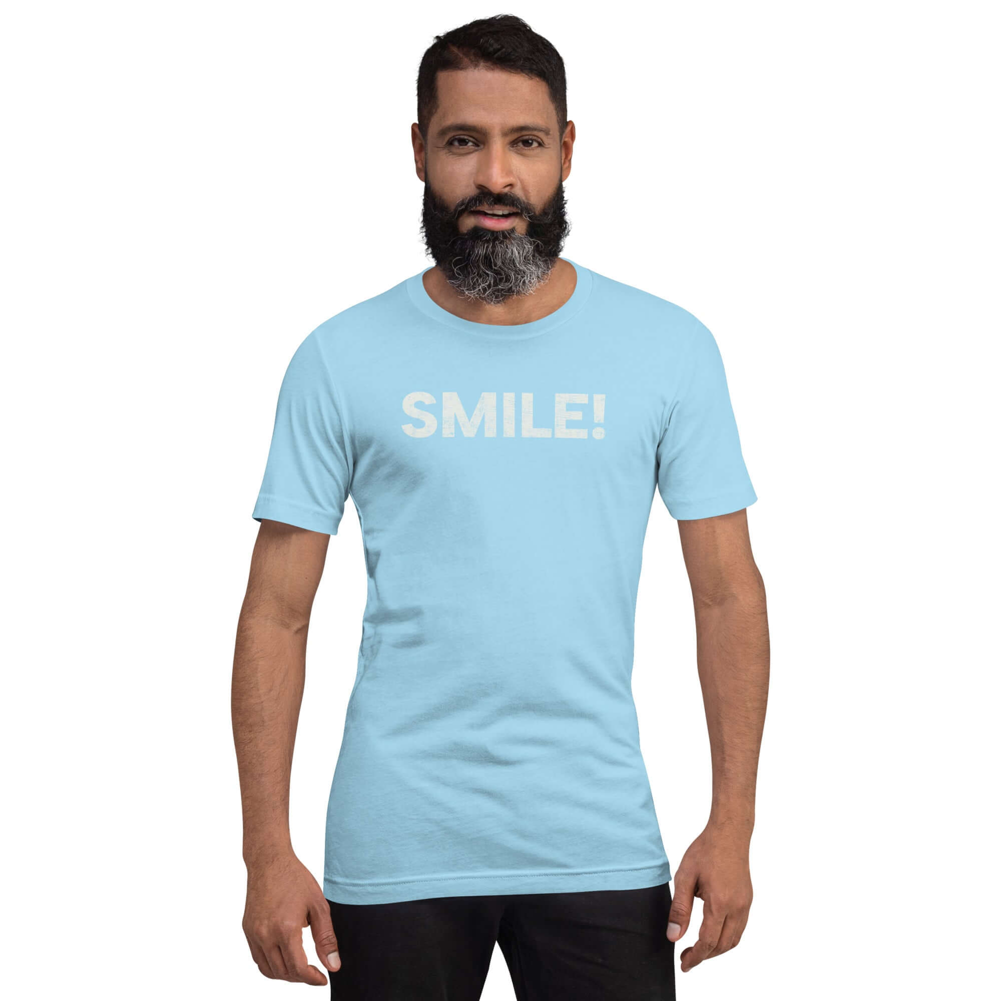 Man wearing a ocean blue Milk Sandwich t-shirt with the word "SMILE!" in bold, distressed white lettering across the chest, standing confidently against a plain background.