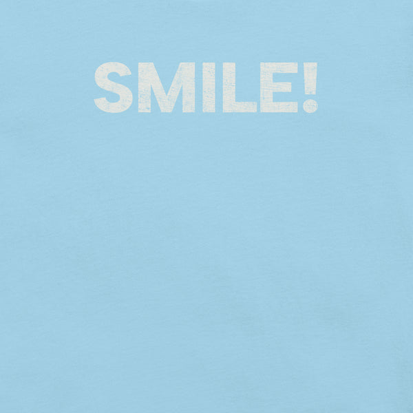Close-up of ocean blue Milk Sandwich t-shirt with the word "SMILE!" printed in bold, distressed white text across the chest.