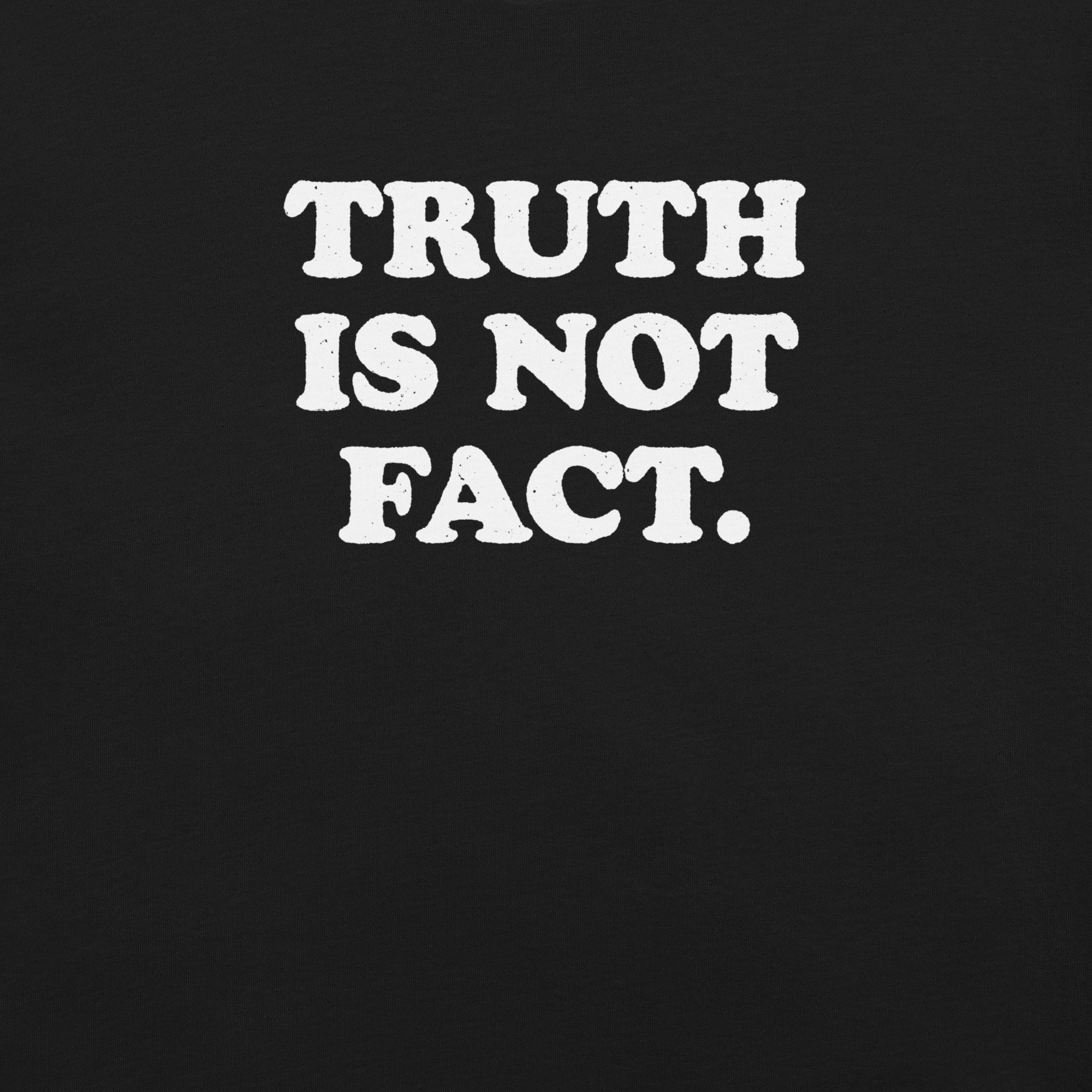 Close-up of black Milk Sandwich T-shirt with bold white text that reads Truth Is Not Fact, minimalist graphic tee with a bold statement.