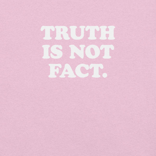 Close-up of pink Milk Sandwich T-shirt with bold white text that reads Truth Is Not Fact, minimalist graphic tee with a bold statement.