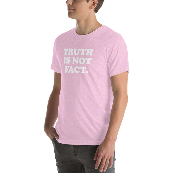 Man wearing a soft pink unisex  Milk Sandwich T-shirt with the phrase "Truth is Not Fact" printed in bold white letters.