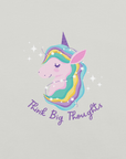 Close-up of a silver Milk Sandwich t-shirt with a pastel unicorn illustration and the phrase Think Big Thoughts in purple script, surrounded by sparkles.