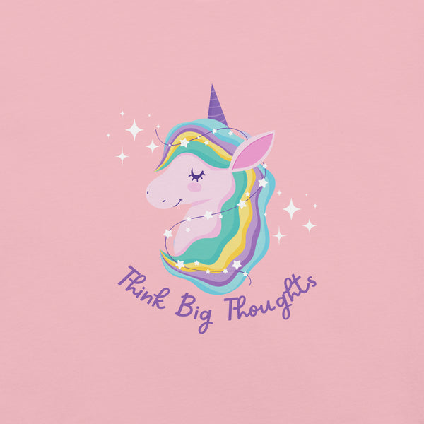 Close-up of a pink Milk Sandwich t-shirt with a pastel unicorn illustration and the phrase Think Big Thoughts in purple script, surrounded by sparkles.