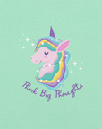 Close-up of a mint Milk Sandwich t-shirt with a pastel unicorn illustration and the phrase Think Big Thoughts in purple script, surrounded by sparkles.