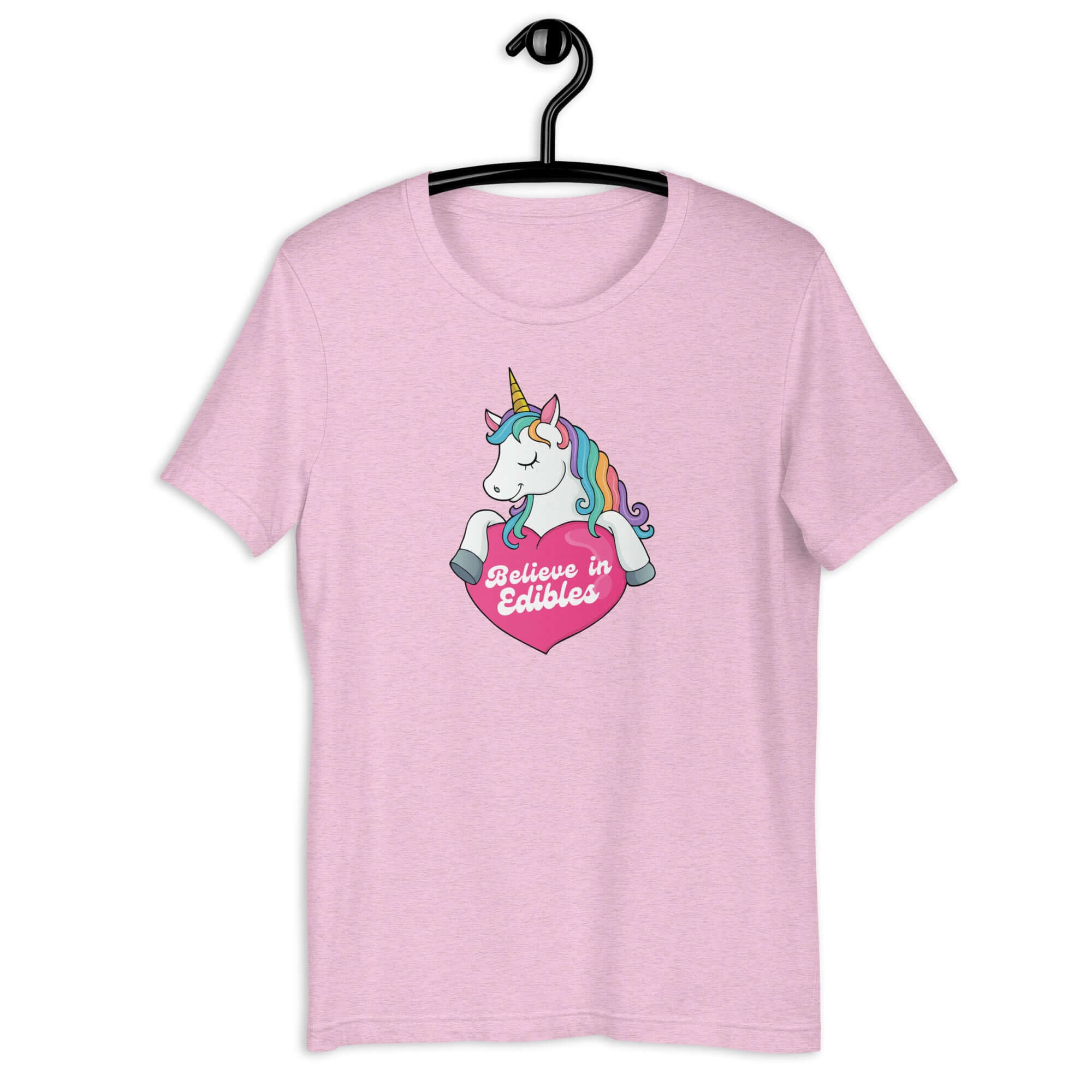 Lilac t-shirt on a hanger with a colorful unicorn graphic above a pink heart that says “Believe in Edibles.”