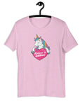 Lilac t-shirt on a hanger with a colorful unicorn graphic above a pink heart that says “Believe in Edibles.”
